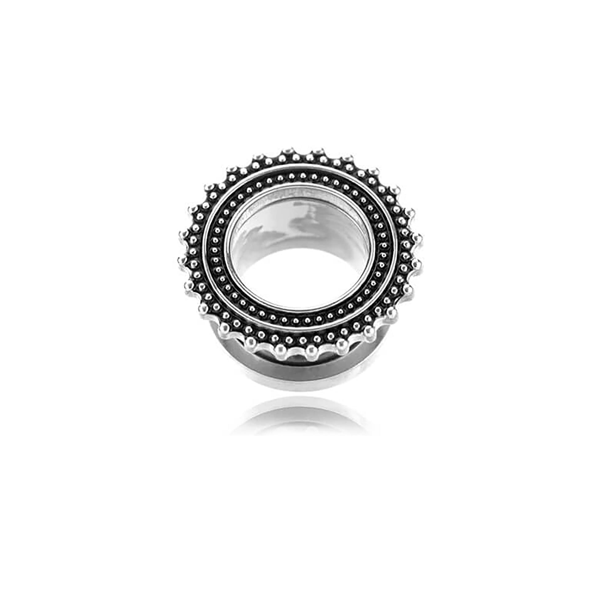 Displayed against a white background is an eye-catching ear gauge from Kaya Movement. This stainless steel plug, designed to evoke the aesthetic of tribal ear tunnels, showcases an intricate beaded pattern. It features a raised black center around the hole, encircled by small silver beads that enhance its stylish and decorative look.